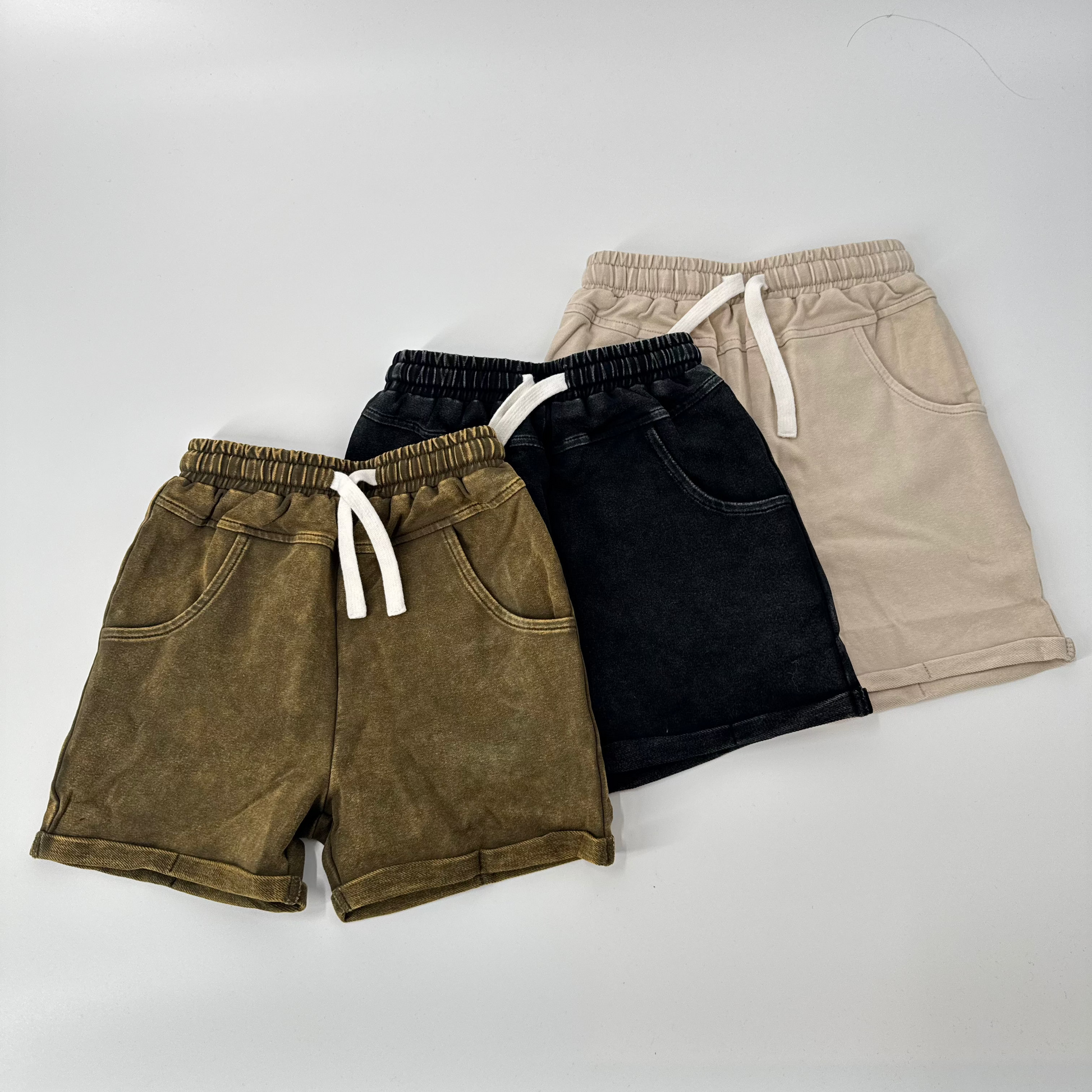 Army green, black, and beige vintage wash shorts, side by side.