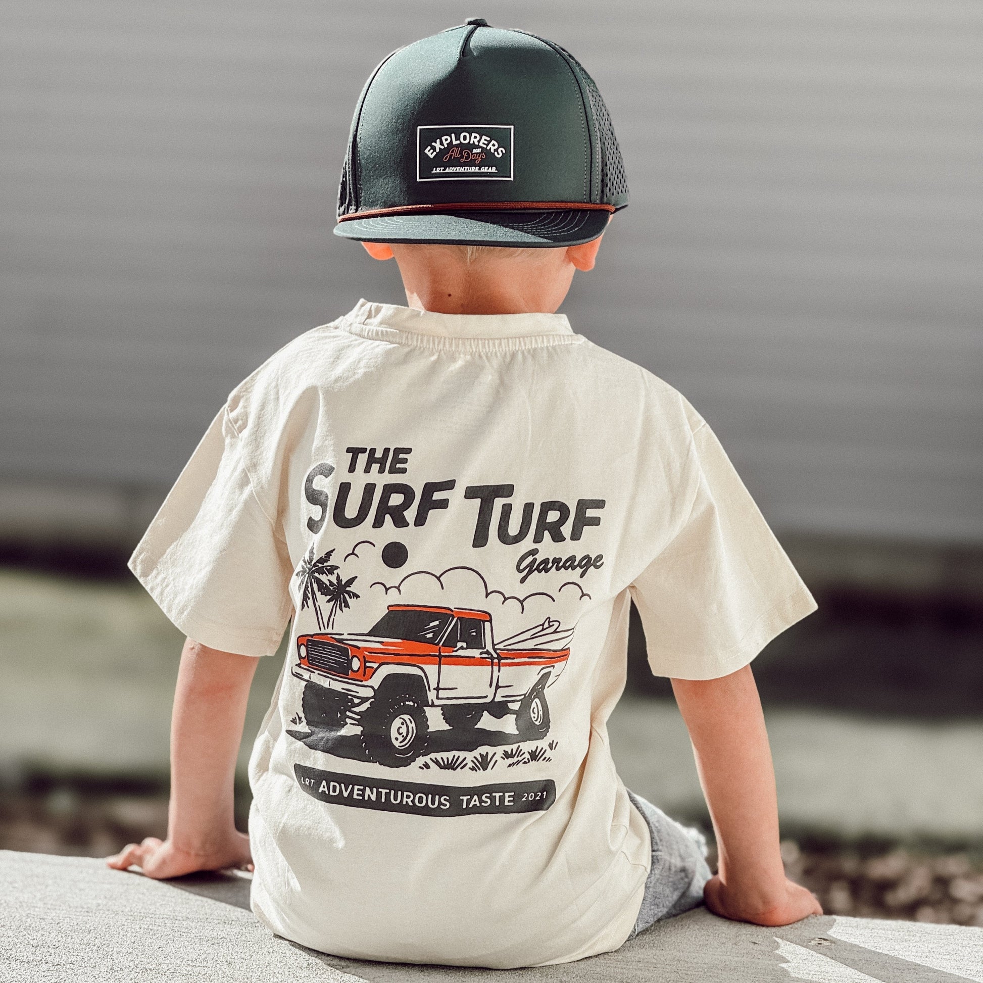 Boy in Surf Turf Tee with vintage truck graphic sitting on ledge