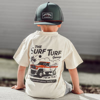 Boy in Surf Turf Tee with vintage truck graphic sitting on ledge