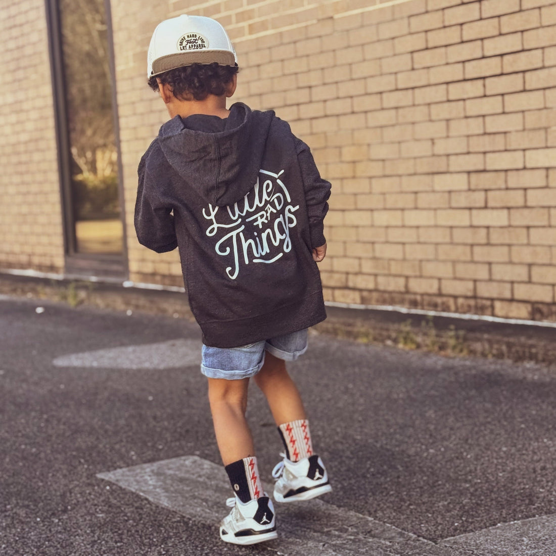 Boy in grey Radiator Hoodie with 'Little Rad Things' design running.