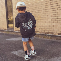 Boy in grey Radiator Hoodie with 'Little Rad Things' design running.