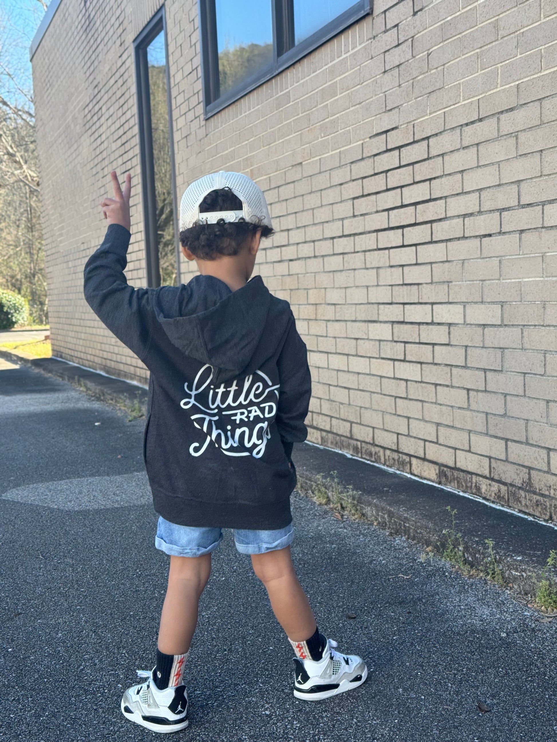 Child in grey Radiator Hoodie with hood up, back view.