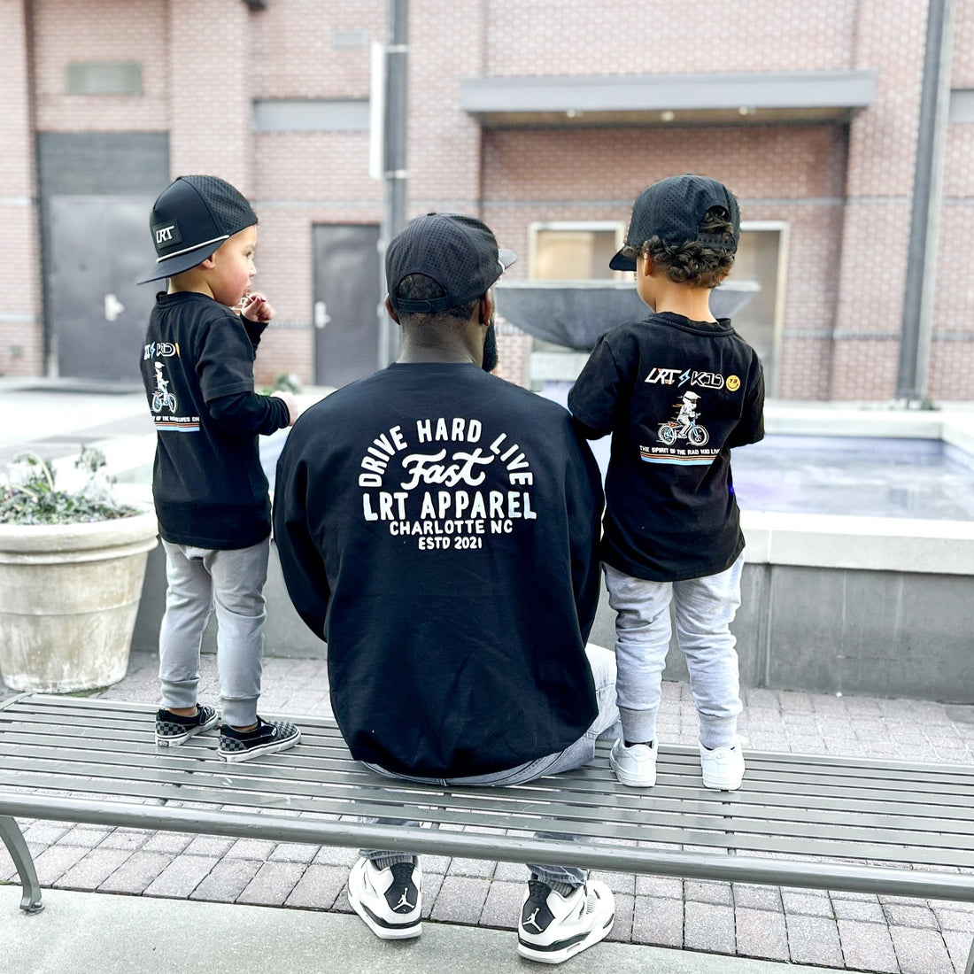 Father and two children wear matching black Apex 'Drive Hard Live Fast' sweatshirts.
