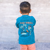 Boy in 'Rad Vibes' graphic tee with arms crossed