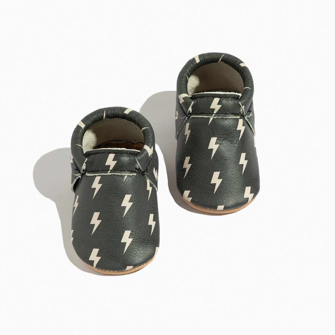 Pair of Ebony Lightning City Baby Shoes, moccasin style with lightning bolt print.