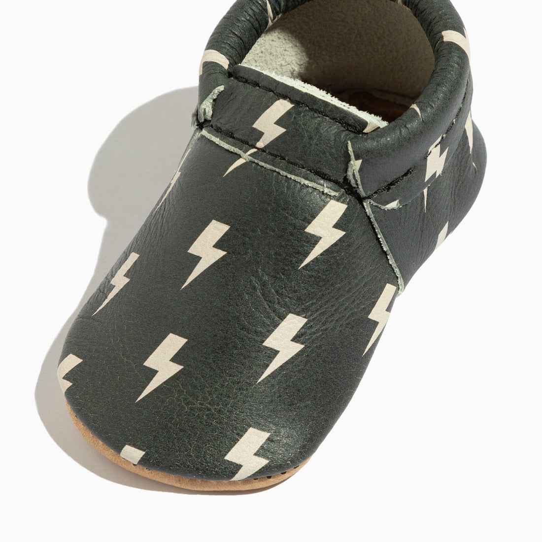 Close-up of Ebony Lightning City Baby Shoe, showcasing lightning bolt pattern.