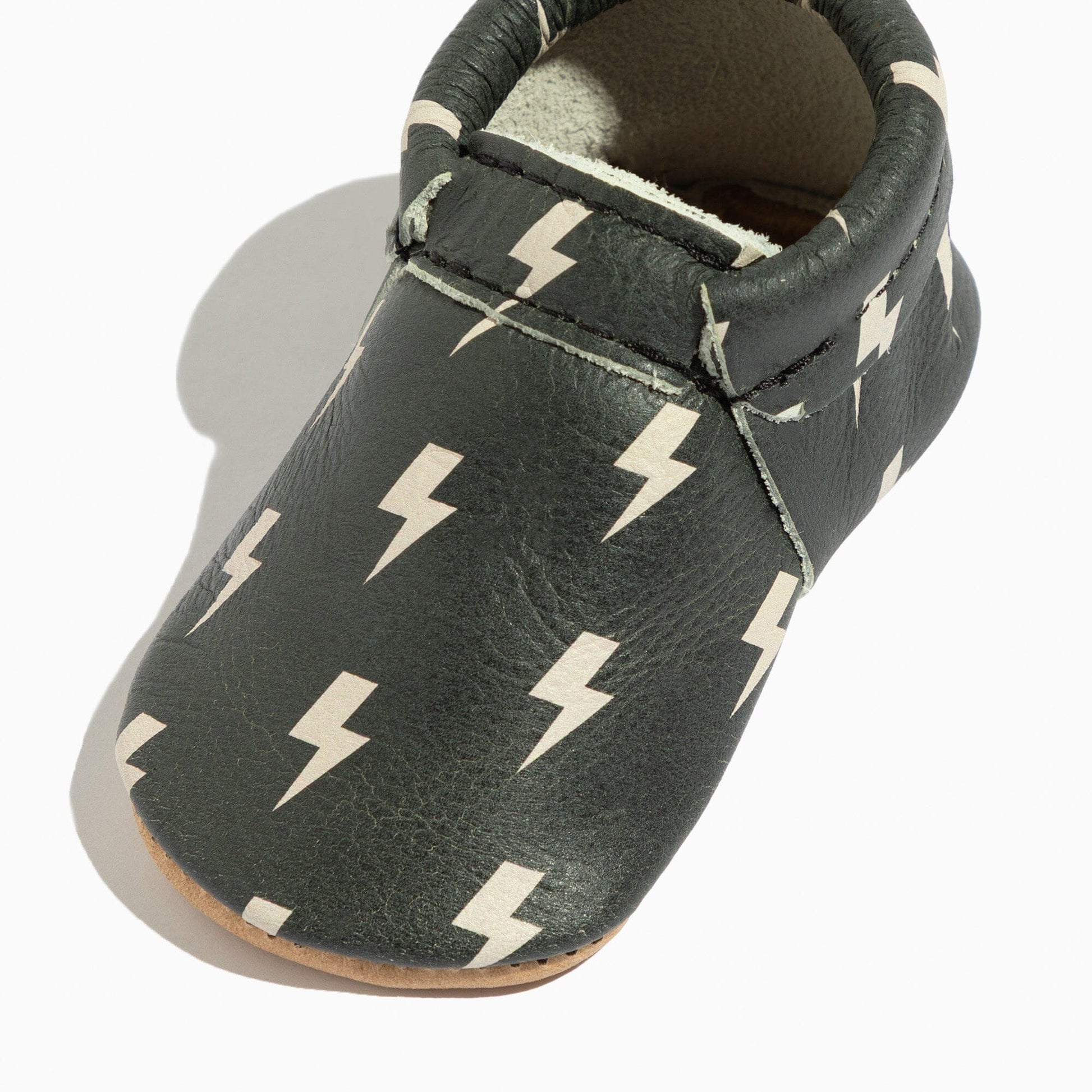 Close-up of Ebony Lightning City Baby Shoe, showcasing lightning bolt pattern.