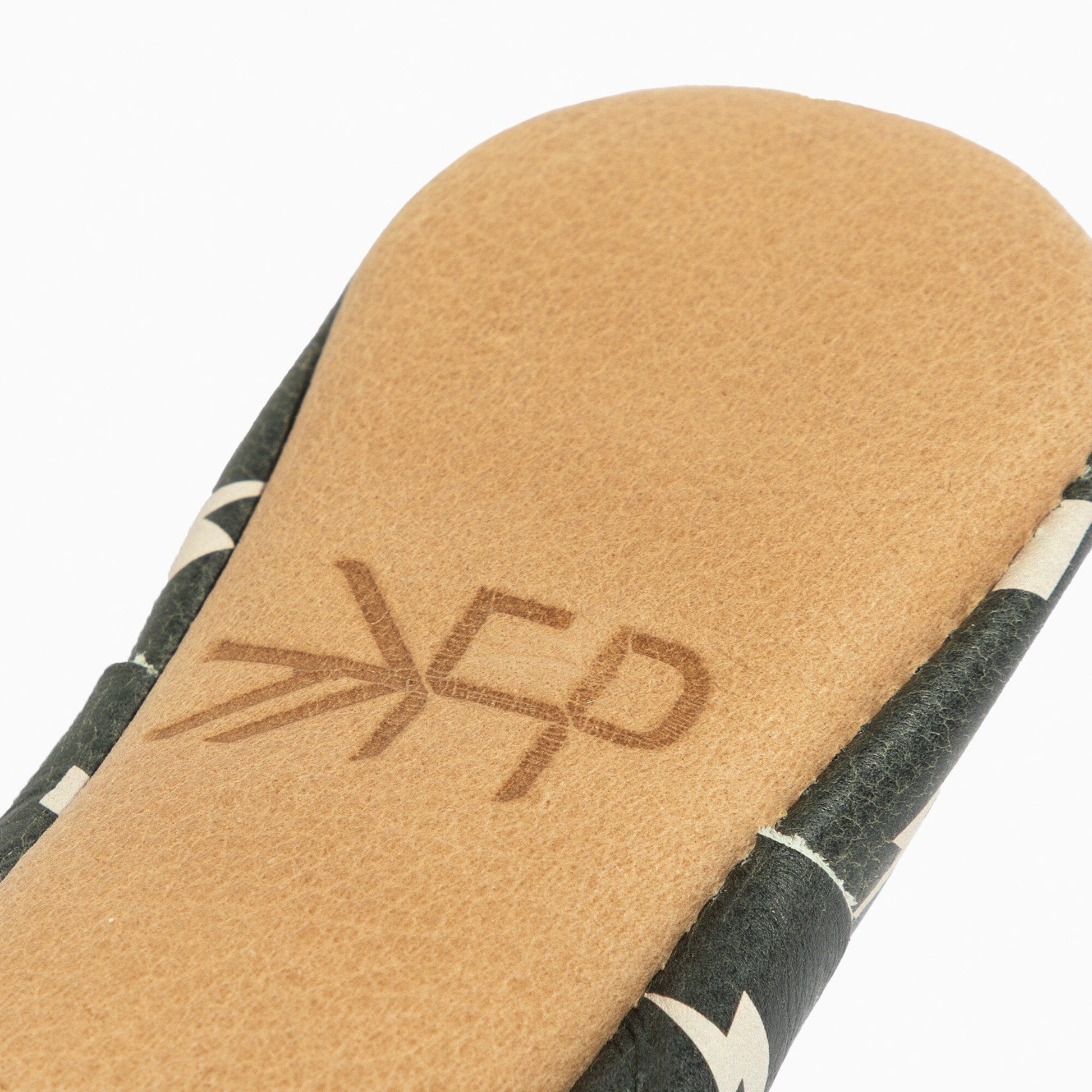 Close-up of the weathered brown leather sole of the baby shoe.