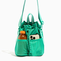 Kelly Motion Bucket Crossbody bag in green with drawstring and crossbody strap.