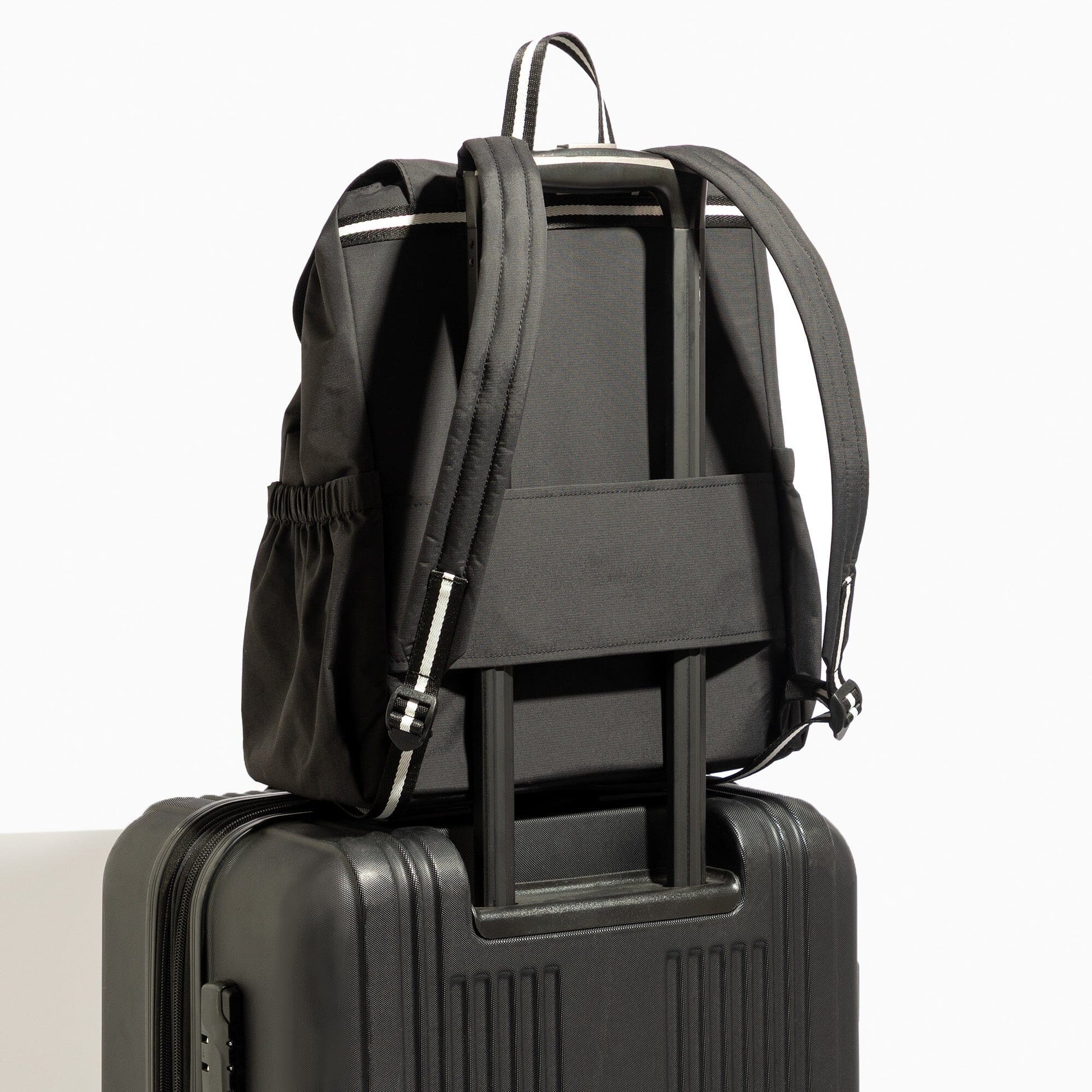 Jet Motion backpack in black with luggage sleeve on suitcase