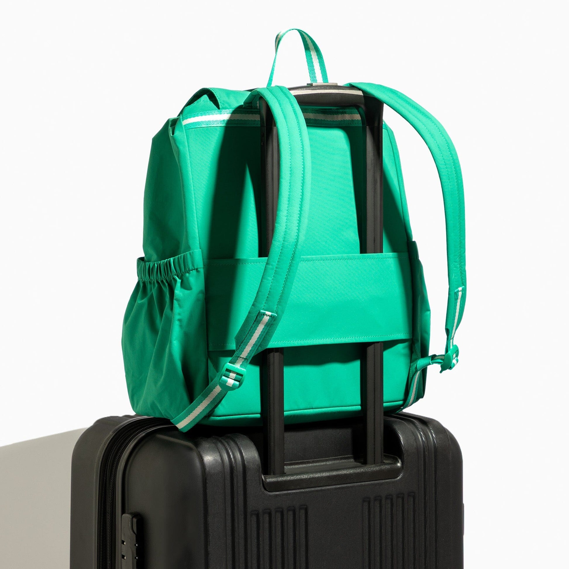 Kelly Motion green backpack attached to suitcase.