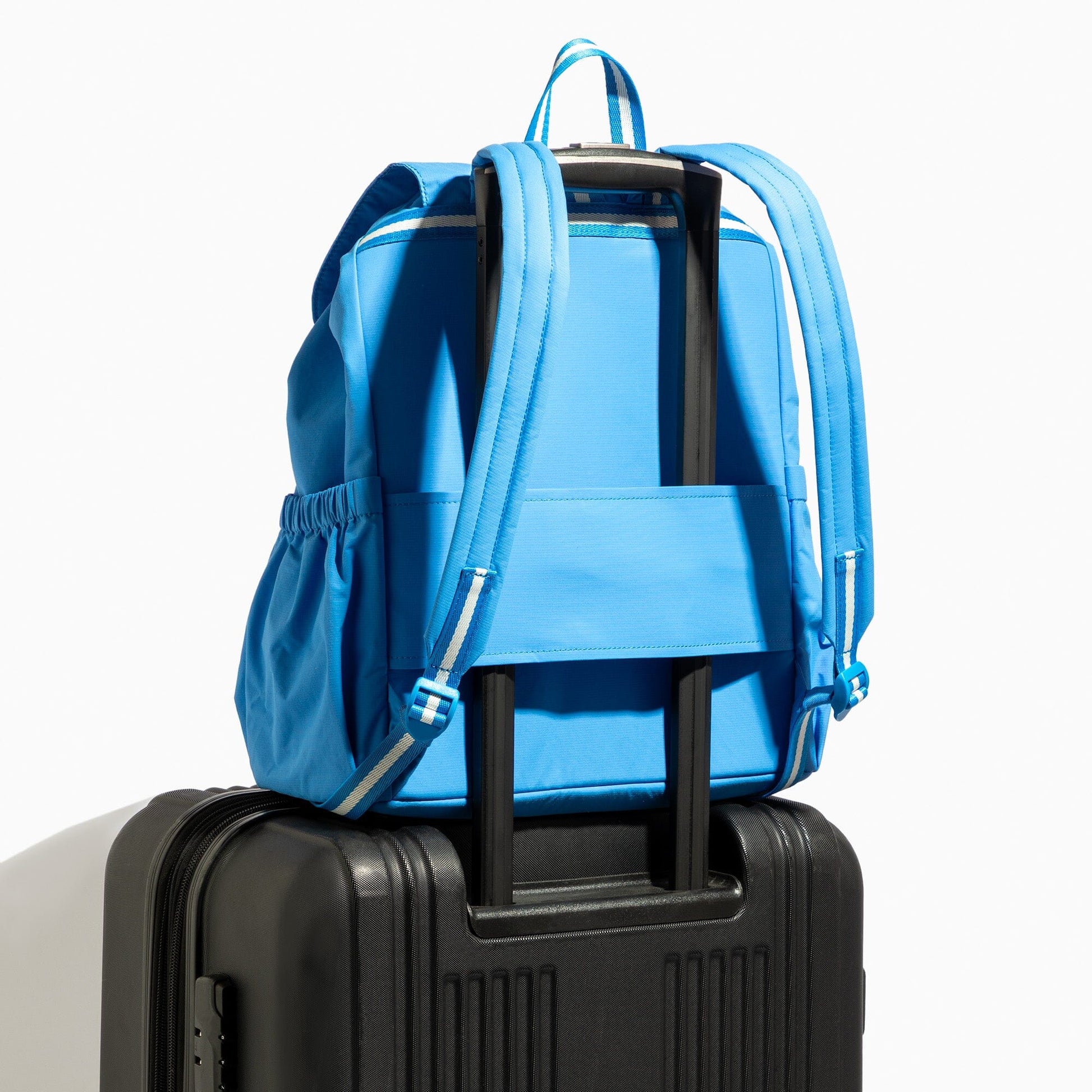 Backpack in blue on top of black luggage.