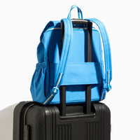Backpack in blue on top of black luggage.