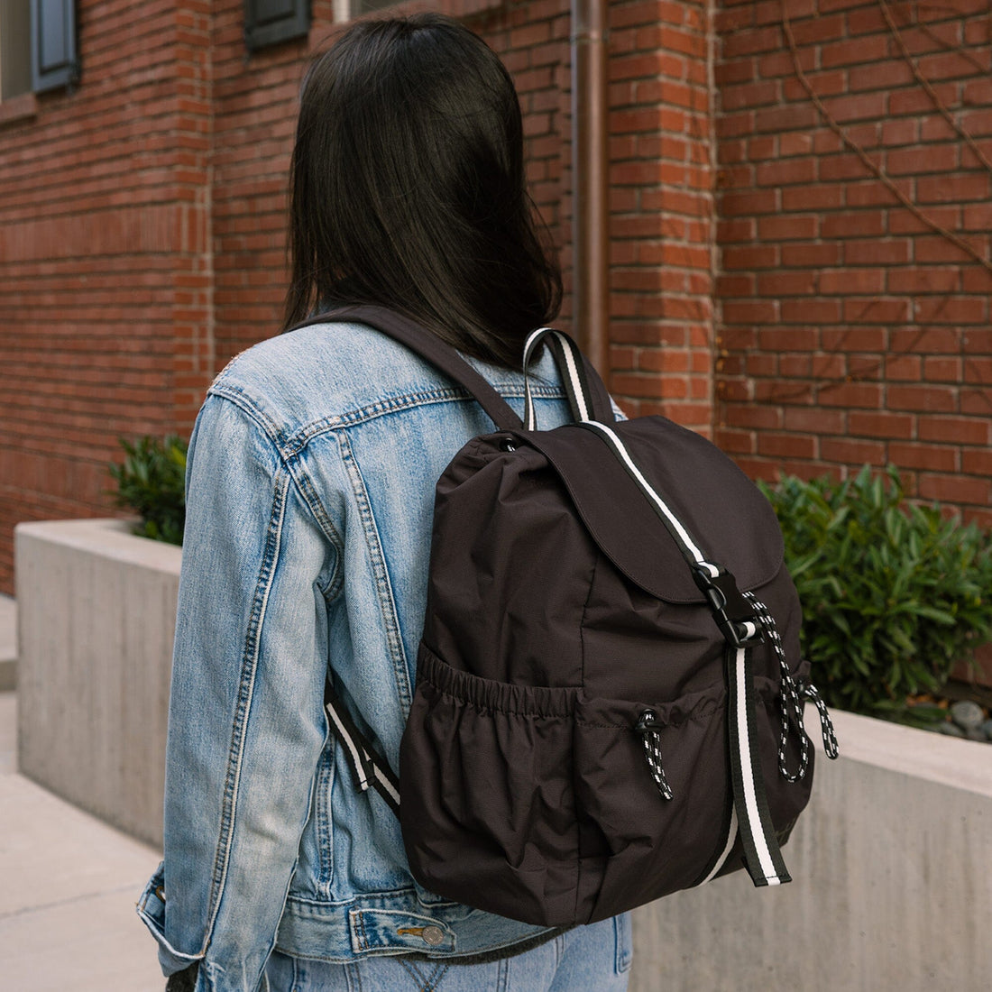 Jet Motion Backpack worn with denim jacket, over the shoulder view
