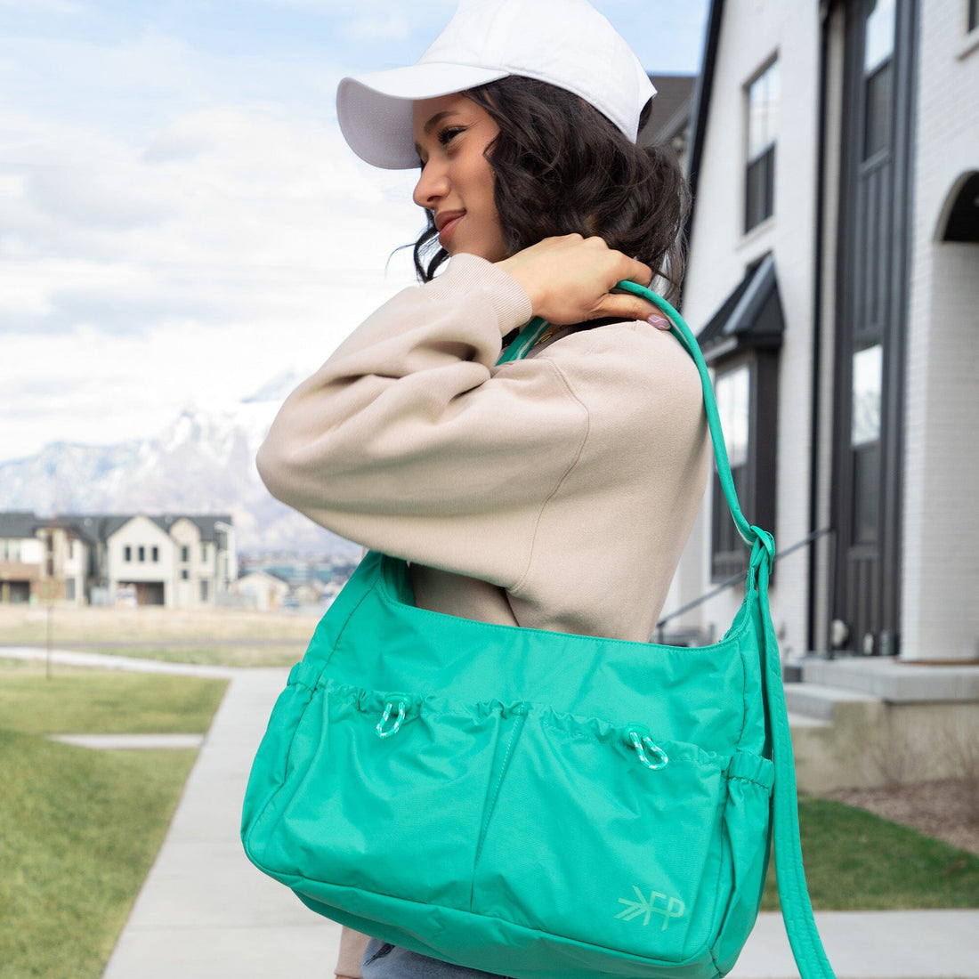 Woman carrying the green Kelly Motion Carryall Tote over her shoulder.