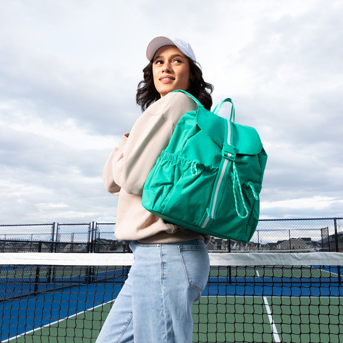 Woman wearing Kelly Motion Drawcord Backpack in green.