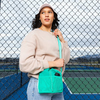 Woman wearing the Kelly Motion Bucket Crossbody bag in green.