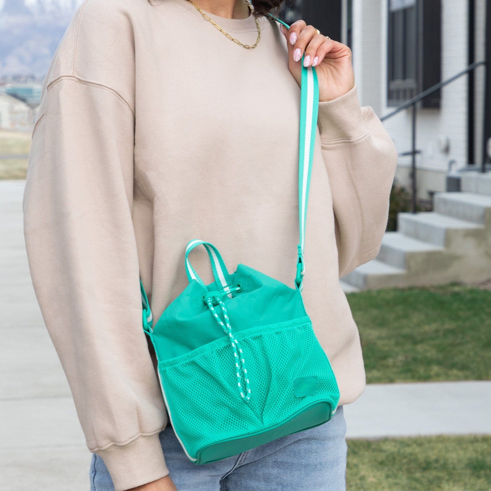 Kelly Motion Bucket Crossbody bag in green with drawstring and crossbody strap.