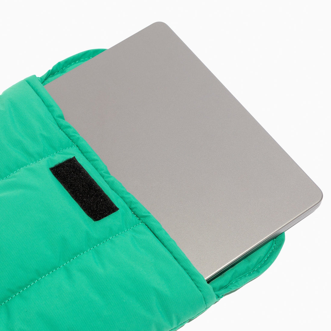 Kelly Motion Laptop Sleeve in green, showing a laptop inside with velcro closure.