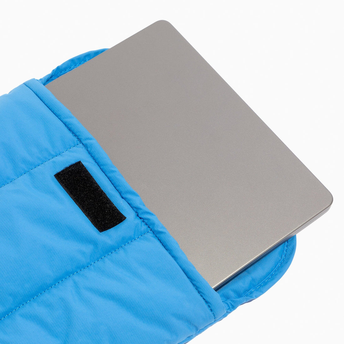 Laptop inside the blue Wave Motion Laptop Sleeve, showing the velcro closure.