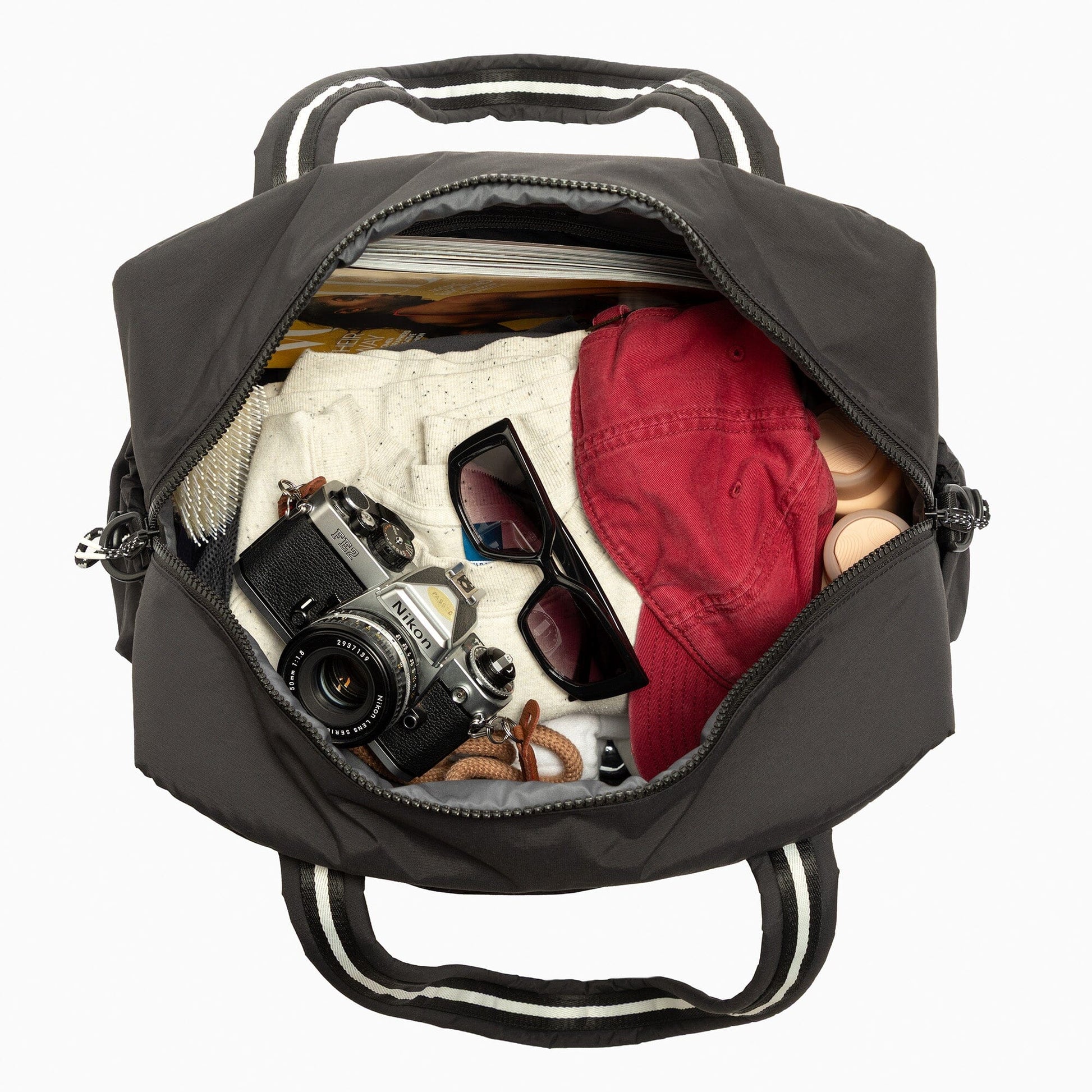 Jet Motion Overnight Duffle in black with top handles and shoulder strap, 'NEW!' badge.