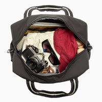 Jet Motion Overnight Duffle in black with top handles and shoulder strap, 'NEW!' badge.