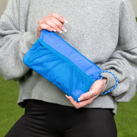 Blue Wave Motion Wristlet Pouch held by a person, showcasing its size and style.