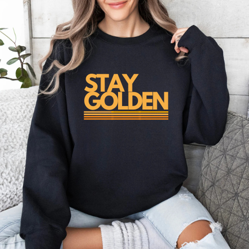 Woman wearing black Stay Golden crew neck sweatshirt.
