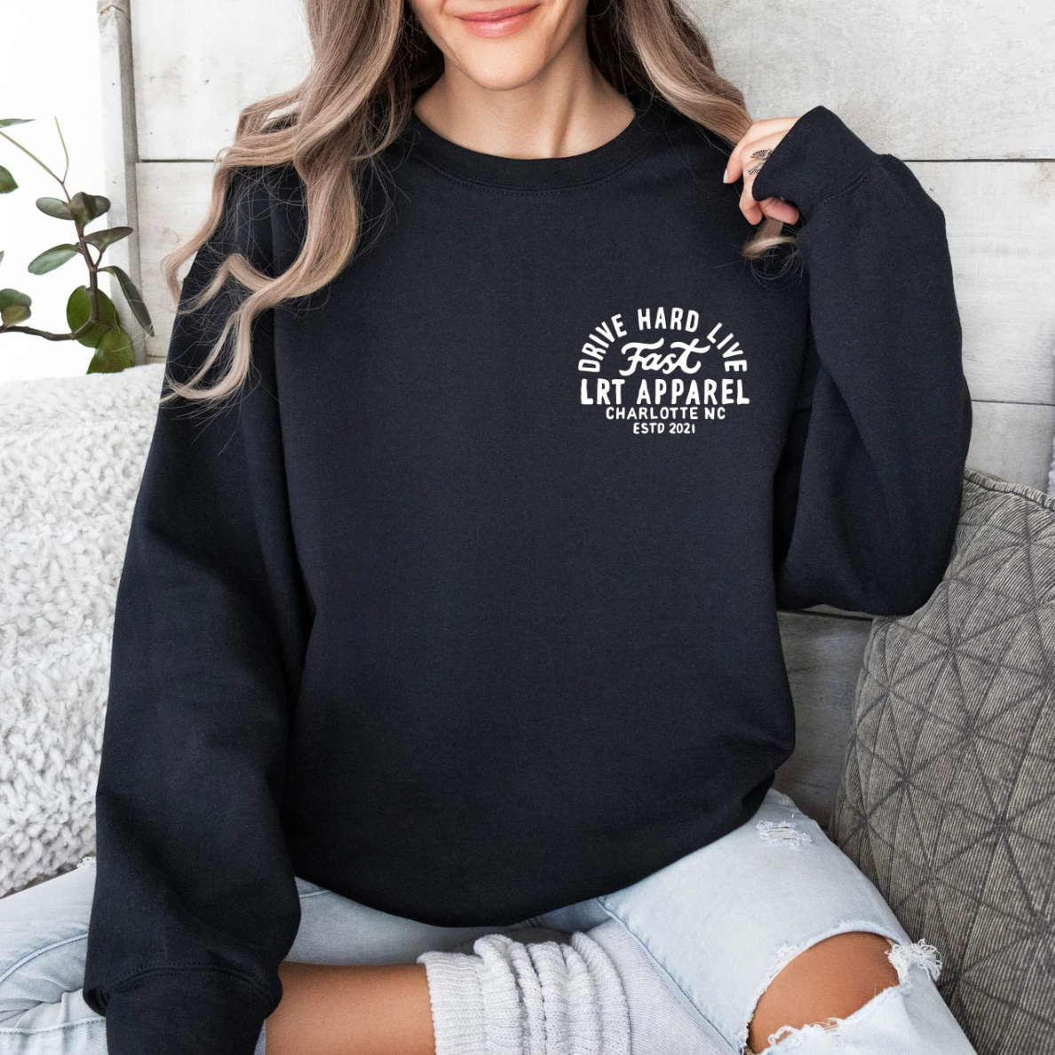 Woman in black Apex crewneck sweatshirt with 'Drive Hard Live Fast' graphic.