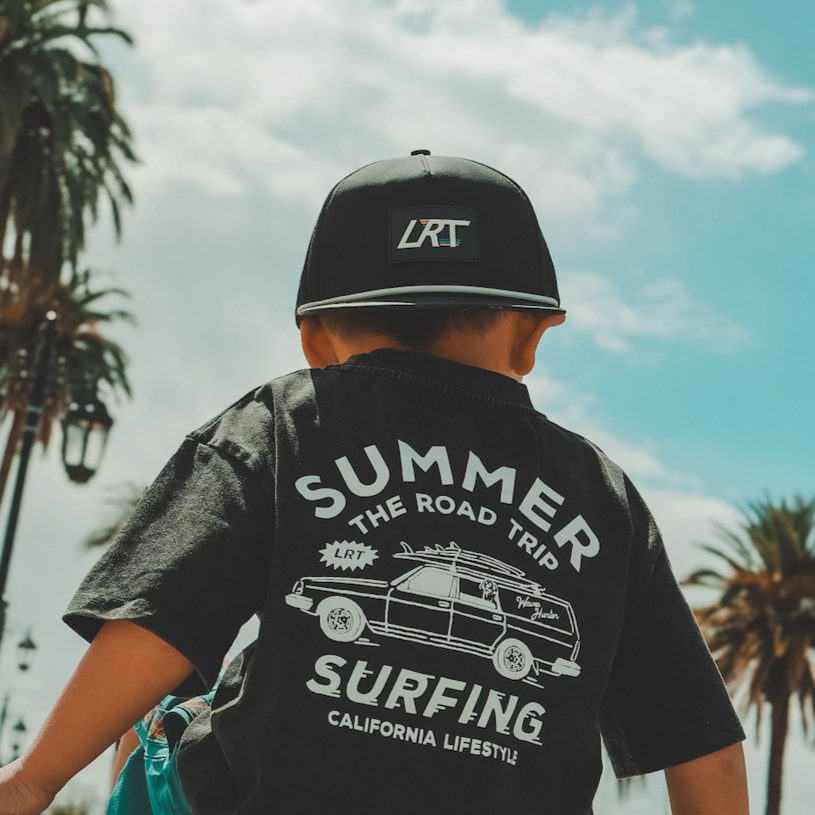 Child wearing black LRT snapback and graphic tee