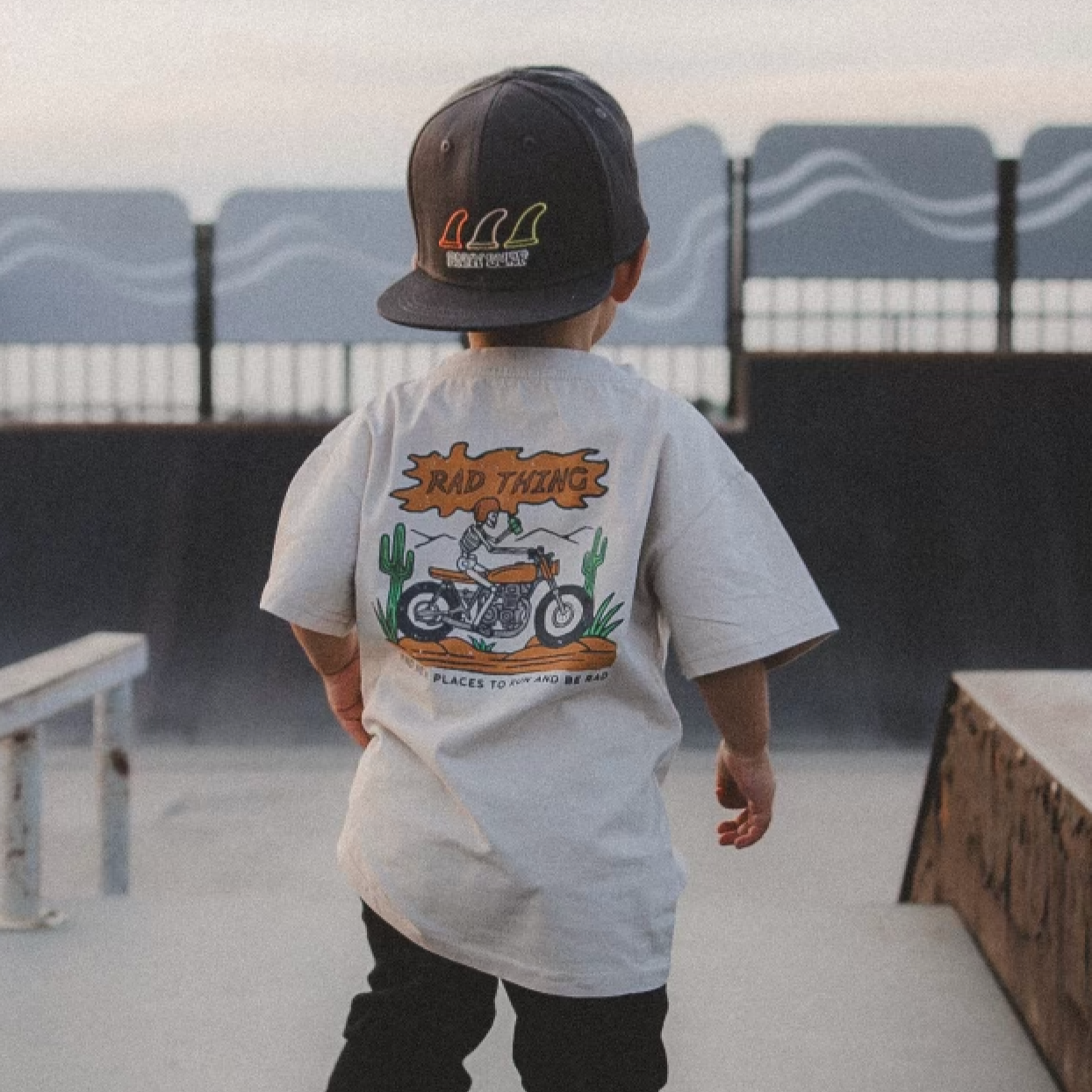 Vintage beige 'Where the Rad Things Are' toddler tee with 'Rad Thing' text graphic.