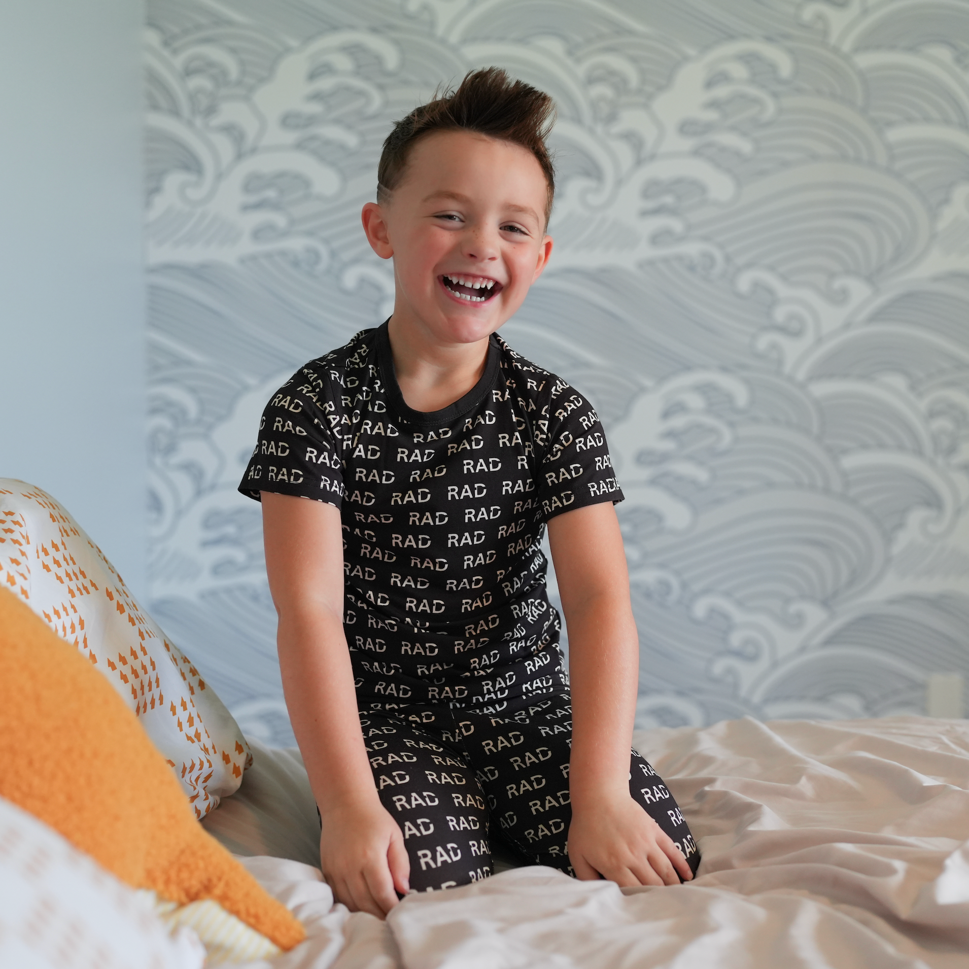 Smiling boy wearing black RAD pajamas.