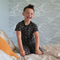 Smiling boy wearing black RAD pajamas.