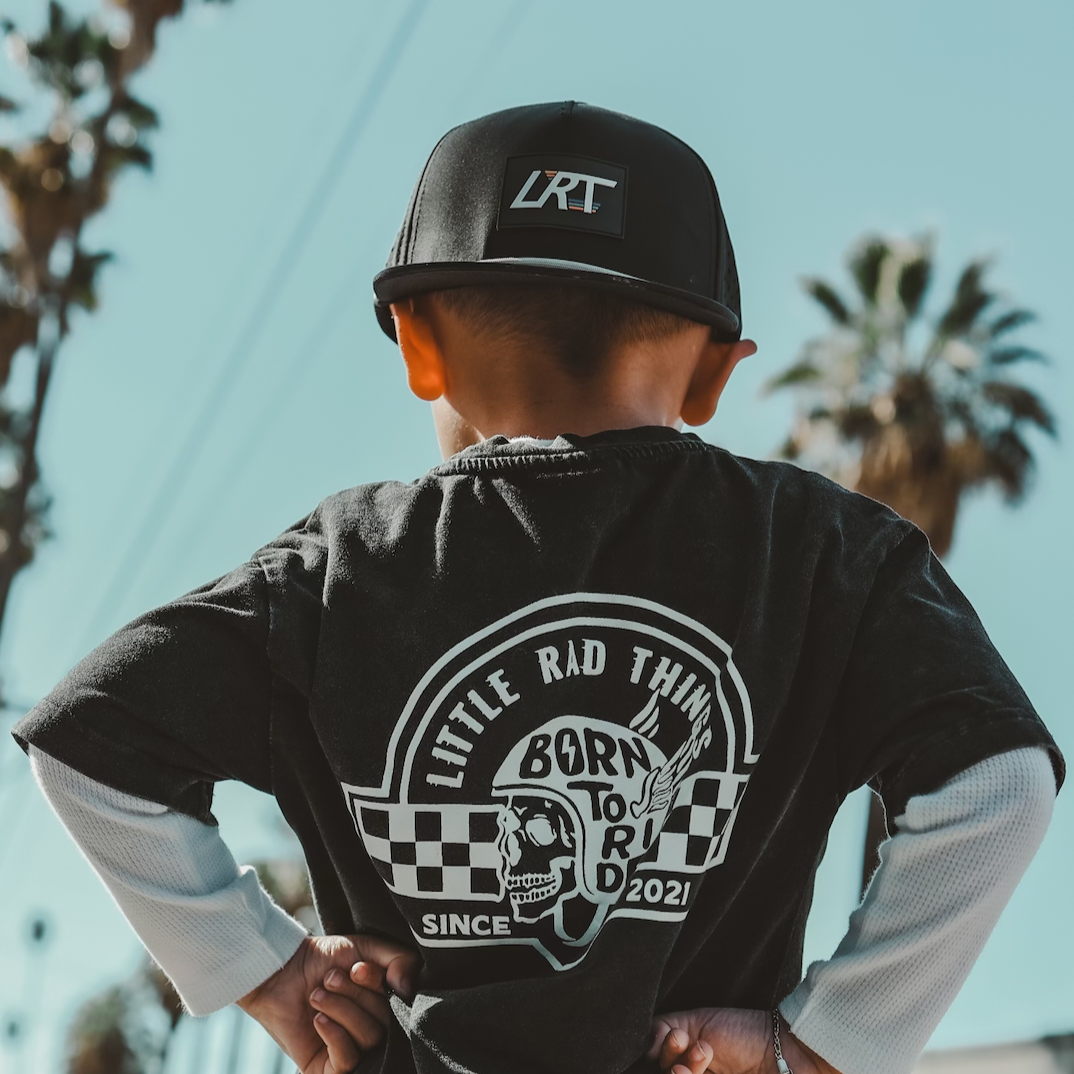 Child wearing black LRT snapback and graphic tee