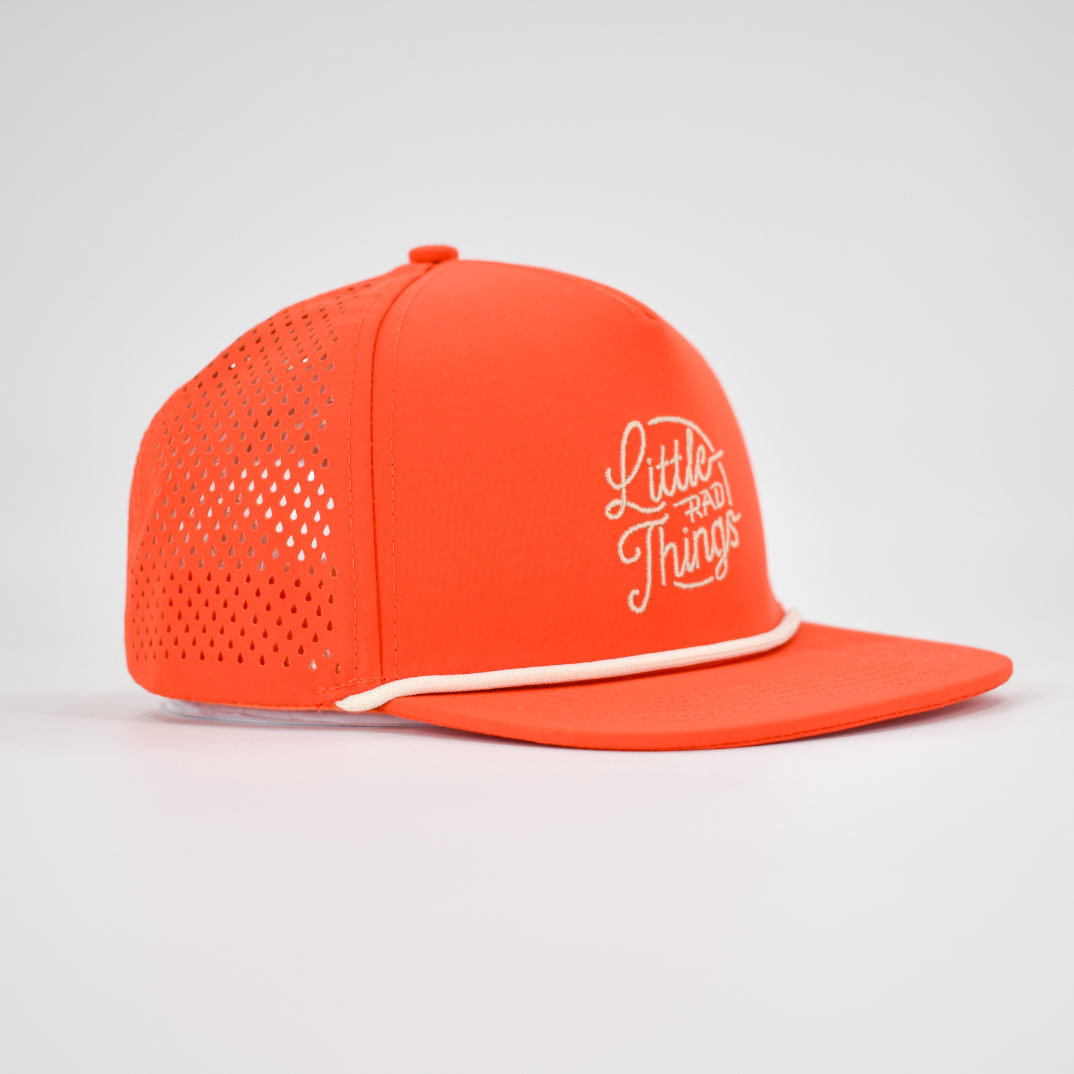 Close-up of the orange waterproof hat showing the curved bill and laser-cut ventilation.