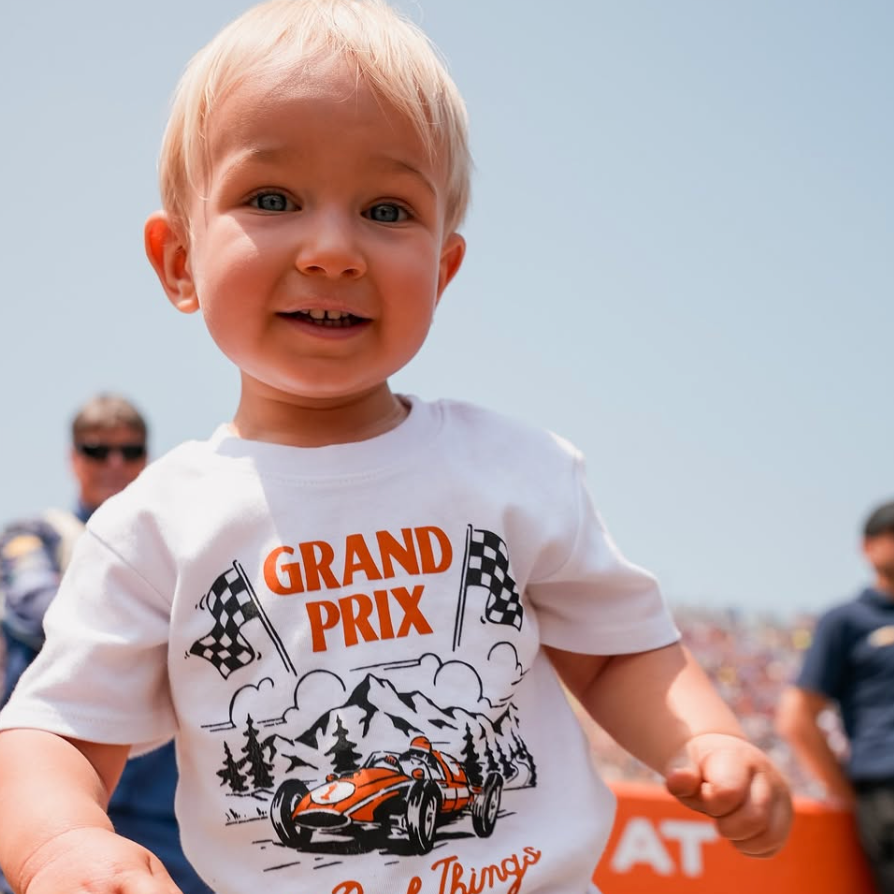 Young boy wearing a Grand Prix themed t-shirt with race car illustration.