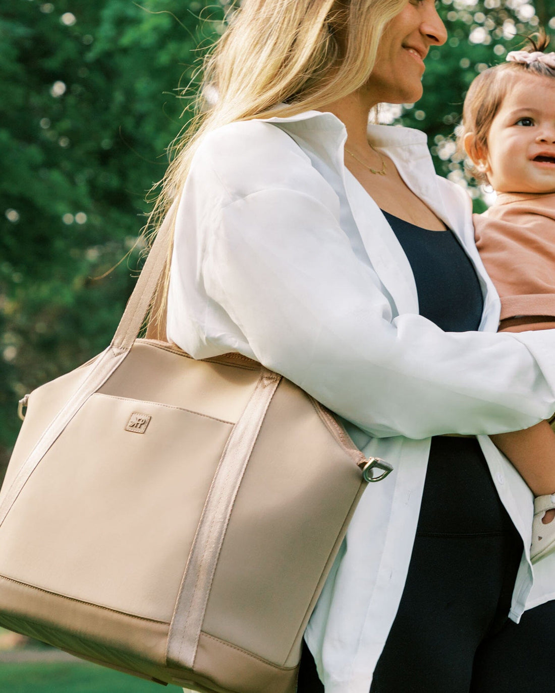 Woman carrying Aspen Seoul Neoprene Tote with baby