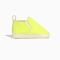 Side view of an extra yellow leather slip-on baby shoe.