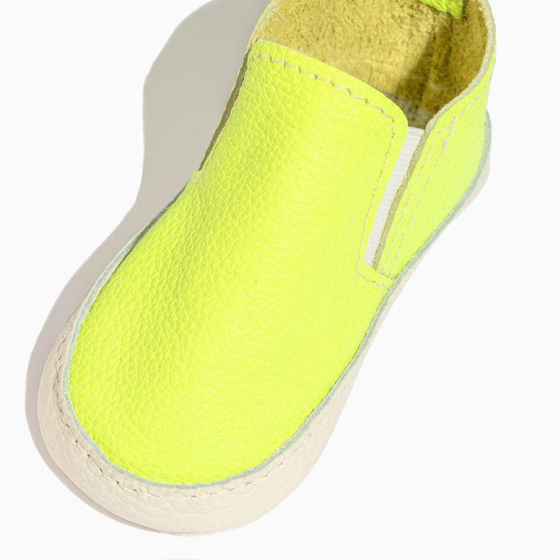 Close-up of a single extra yellow leather baby slip-on shoe.