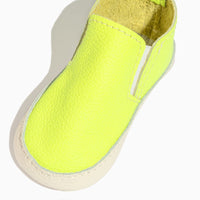 Close-up of a single extra yellow leather baby slip-on shoe.
