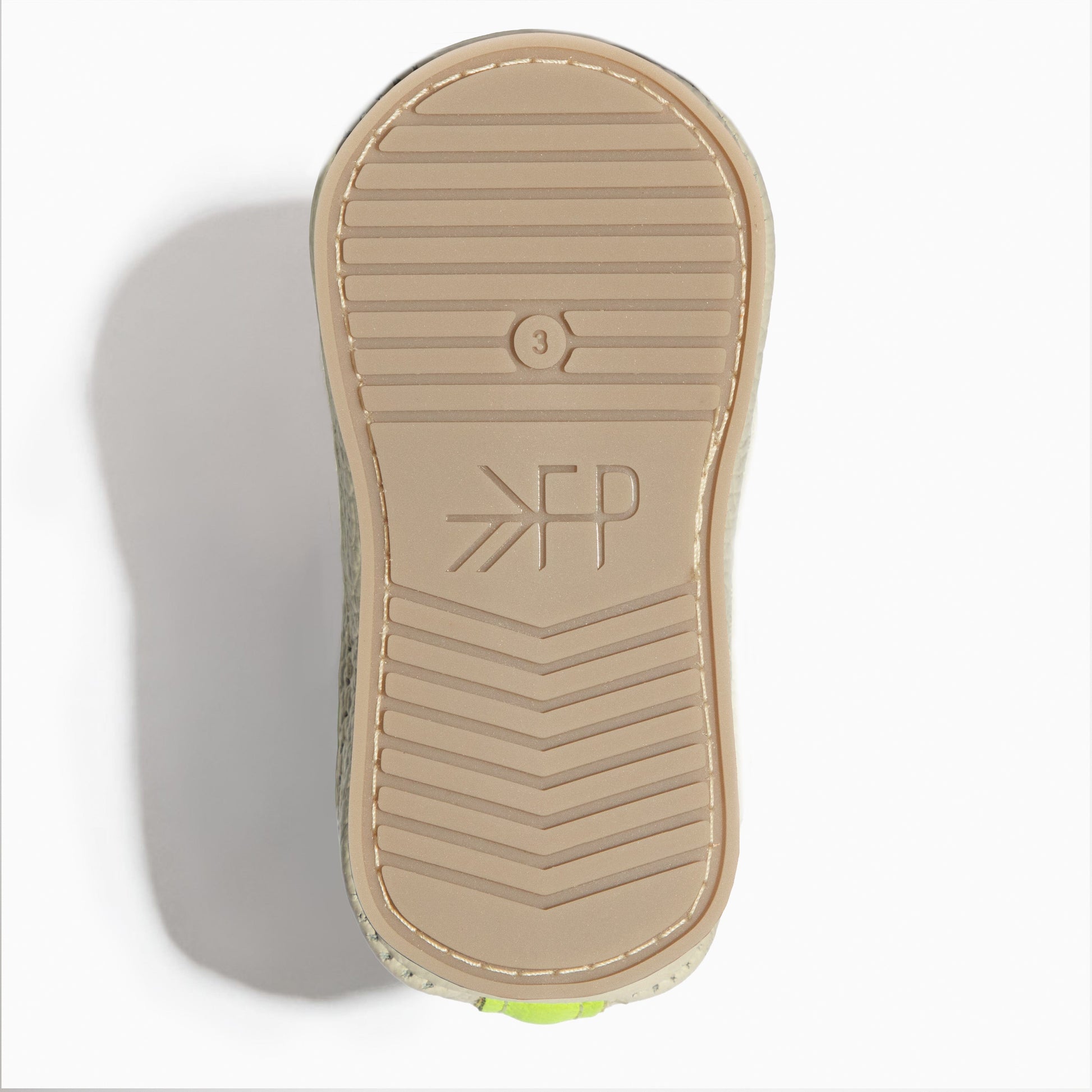 Close-up of the white leather sole of a baby shoe.