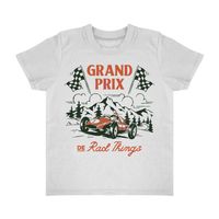 Happy child in Grand Prix t-shirt at race with crowd background.