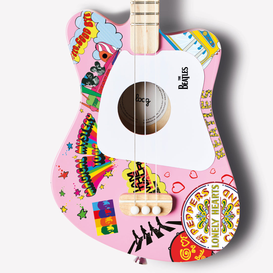 Close-up of The Beatles Loog Mini Guitar with pink body and colorful graphics.