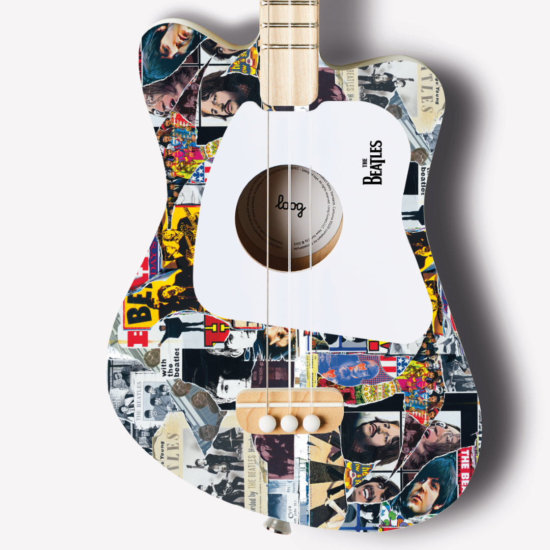 Close-up of The Beatles Loog Mini Guitar featuring collage design and white pickguard.