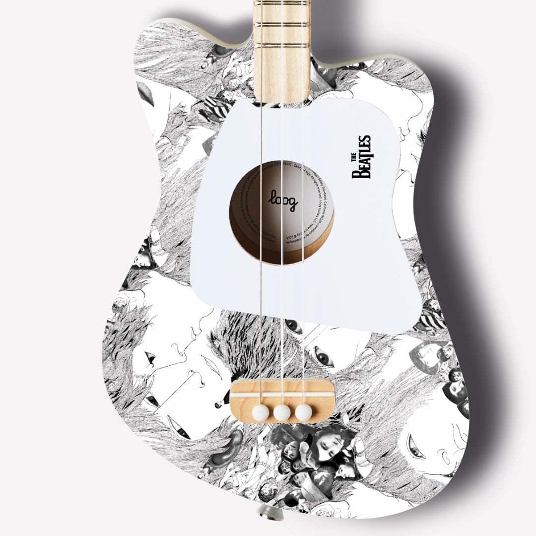 Close-up of The Beatles Loog guitar featuring black and white character design.
