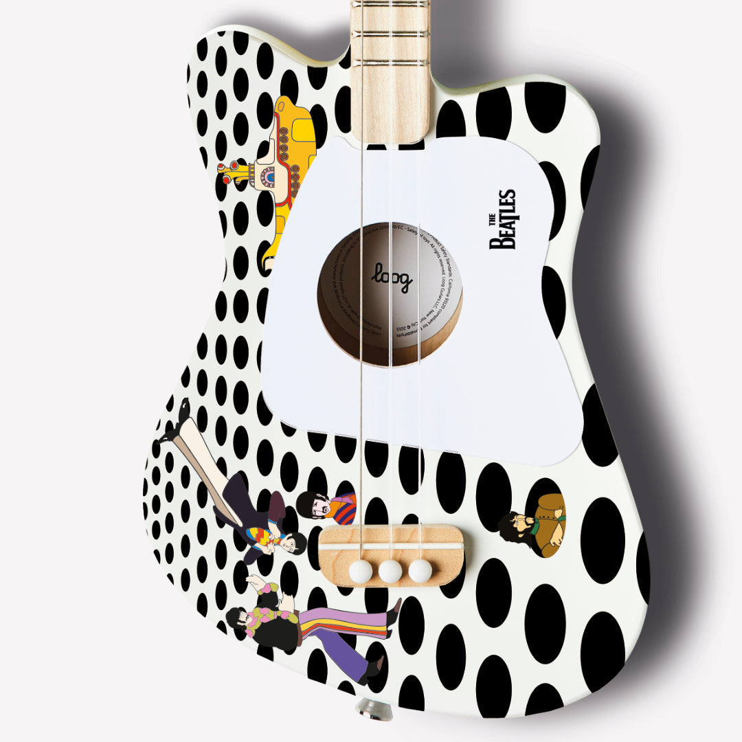 Close-up of The Beatles Loog Mini guitar featuring album art and polka dot design