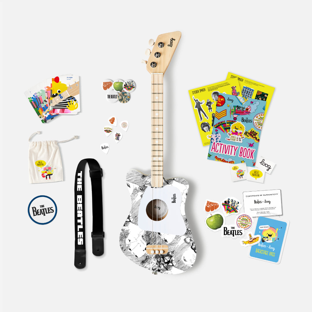 The Beatles Loog Mini Guitar set with guitar, strap, picks, activity book, and stickers.