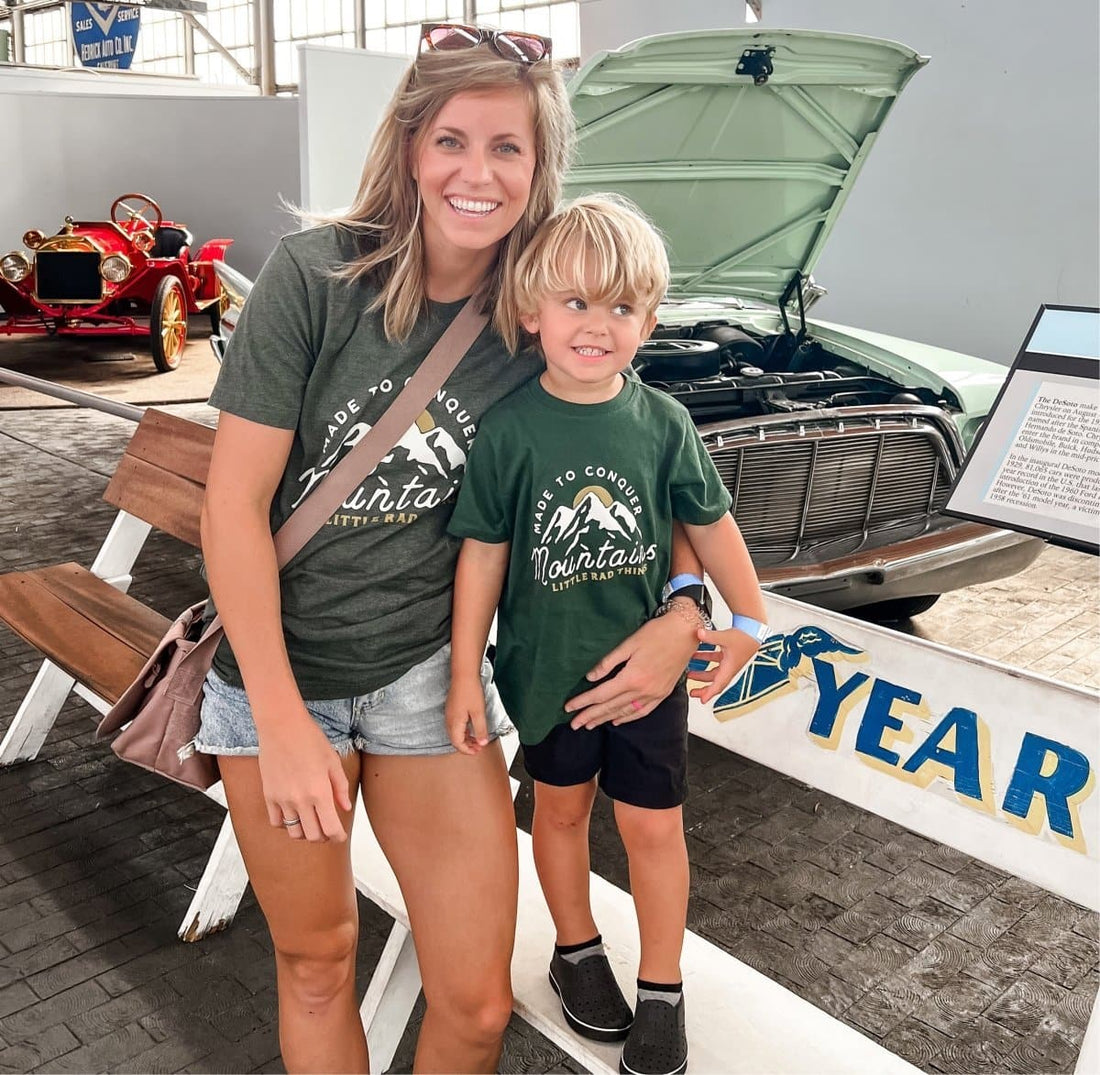 Mother and son in matching green 'Made To Conquer Mountains' tees.