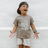 Smiling child wearing THE BRONCO Ocean Cubs Wear TEE with khaki shorts