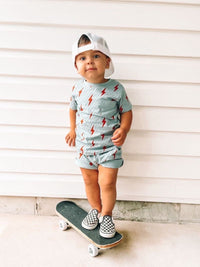 Child on skateboard wearing Spark Retro Shorts and matching shirt.